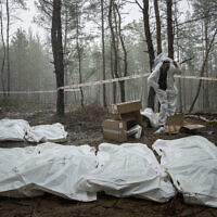 Bags with dead bodies are seen during the exhumation in the recently retaken area of Izium, Ukraine, September 16, 2022. (AP Photo/Evgeniy Maloletka)