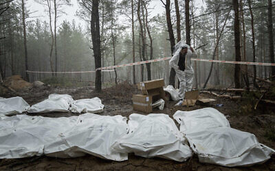 Bags with dead bodies are seen during the exhumation in the recently retaken area of Izium, Ukraine, September 16, 2022. (AP Photo/Evgeniy Maloletka)