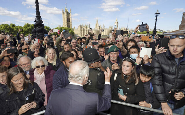 Britain's King Charles III meets members of the public in the queue along the South Bank, near to Lambeth Bridge as they wait to view Queen Elizabeth II lying in state in London, Sept. 17, 2022. (Aaron Chown/Pool Photo via AP)
