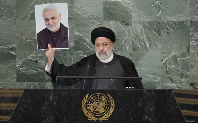 President of Iran Ebrahim Raisi holds up a photo of assassinated Iranian Gen. Qassem Soleimani as he addresses the 77th session of the United Nations General Assembly, at UN headquarters, September 21, 2022. (Mary Altaffer/AP)