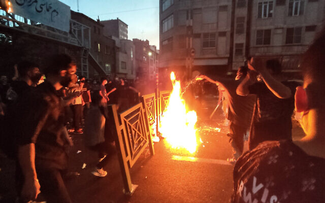 In this Sept. 21, 2022, photo taken by an individual not employed by The Associated Press and obtained by the AP outside Iran, protesters make fire and block the street during a protest over the death of a woman who was detained by the morality police, in downtown Tehran, Iran. (AP Photo)