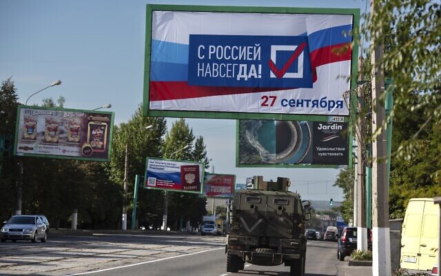 FILE - A military vehicle drives along a street with a billboard that reads: "With Russia forever, September 27", prior to a referendum in Luhansk, Luhansk People's Republic controlled by Russia-backed separatists, eastern Ukraine, September 22, 2022. (AP Photo/File)
