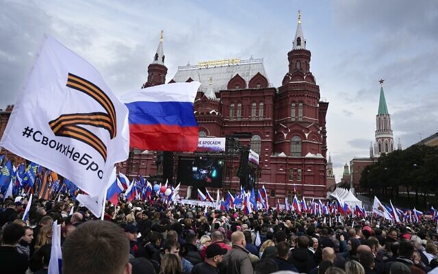Demonstrators hold Russian state flags and flags with with the letter Z, which has become a symbol of the Russian military, and a hashtag reading “We don’t abandon our own” during a rally support the referendum on annexing Russian-occupied parts of Ukraine, on Manezhnaya Square near the Kremlin and Red Square with the Historical Museum in the background in Moscow, Russia, September 23, 2022. (AP Photo/Alexander Zemlianichenko)