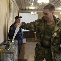 A Luhansk People's Republic serviceman votes in a polling station in Luhansk, Luhansk People's Republic, controlled by Russia-backed separatists, eastern Ukraine, September 23, 2022. (AP Photo, File)