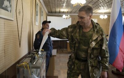 A Luhansk People's Republic serviceman votes in a polling station in Luhansk, Luhansk People's Republic, controlled by Russia-backed separatists, eastern Ukraine, September 23, 2022. (AP Photo, File)