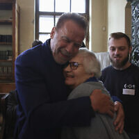Arnold Schwarzenegger, left, hugs Holocaust survivor Lydia Maksimovicz, right, in Oswiecim, Poland, September 28, 2022. (AP Photo/Michal Dyjuk)