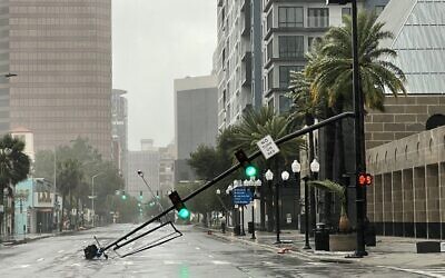 A stoplight pole at Livingston Street, blown down by Hurricane Ian winds, rests on Orange Avenue in Downtown Orlando, Florida, September 29, 2022. (Willie J. Allen Jr./Orlando Sentinel via AP)