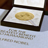 The Nobel diploma and medal in physiology or medicine presented to Charles M. Rice is displayed, Tuesday, Dec. 8, 2020, during a ceremony in New York.  (Angela Weiss/Pool Photo via AP, File)