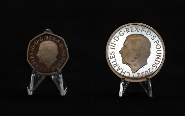 Two new coins bearing the official coinage portrait of King Charles III, on the left is the new 50 pence coin, and right is the new 5 pound commemorative coin, which will be among the first coins to bear the new king's head, during a press preview in London, September 29, 2022. (AP Photo/Alastair Grant)