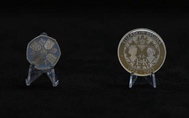 The obverse of two new coins bearing official coinage portrait of King Charles III, on the left is the new 50 pence coin, and right is the new 5 pound commemorative coin, which will be among the first coins to bear the new king's head, during a press preview in London, September 29, 2022. (AP Photo/Alastair Grant)