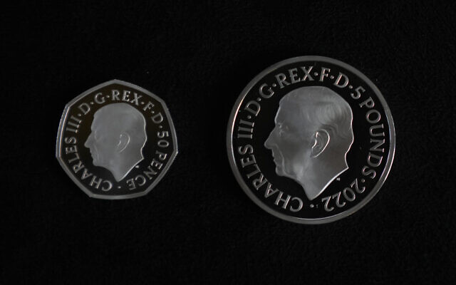 Two new coins bearing official coinage portrait of King Charles III, on the left is the new 50 pence coin, and right is the new 5 pound commemorative coin, which will be among the first coins to bear the new king's head, during a press preview in London, September 29, 2022. (AP Photo/Alastair Grant)