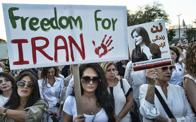 Iranian women hold signs during a vigil with the Iranian American Women Foundation (IAWF) in solidarity with women in Iran who are fighting for their human rights, in West Hollywood, Calif. on Thursday, Sept. 29, 2022. (AP Photo/Richard Vogel)