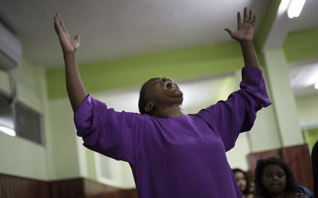 A member of the Assemblies of God Ministry of Restoration church reacts to the words of Pentecostal preacher Dione dos Santos in the Coreia shantytown, in Rio de Janeiro, Brazil, November 28, 2014. Evangelical Christianity is the fastest growing religious segment in Brazil and its population is exploding. (AP Photo/Felipe Dana)