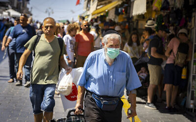 People, some with face masks, shop for groceries at the Mahane Yehuda market in Jerusalem on July 7, 2022. (Olivier Fitoussi/Flash90)
