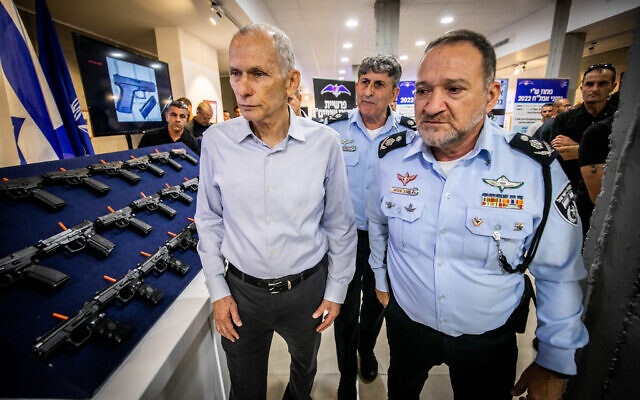 Chief of police Kobi Shabtai, right, and Public Security Minister Omer Barlev look at a display of illegal weapons during a ceremony in Ma'ale Adumim, after a large police operation against illegal gun dealers, September 7, 2022. (Oren Ben Hakoon/Flash90)