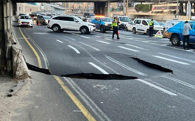 Police at the site of a sinkhole on the Ayalon Highway in Tel Aviv on September 17, 2022. (Avshalom Sassoni/Flash90)