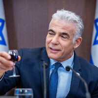 Prime Minister Yair Lapid raises a glass in toast as he leads a cabinet meeting at the Prime Minister's Office in Jerusalem on September 18, 2022. (Olivier Fitoussi/Flash90)