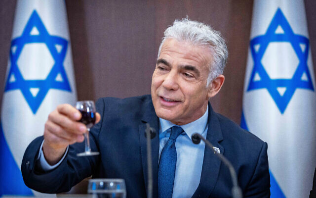 Prime Minister Yair Lapid raises a glass in toast as he leads a cabinet meeting at the Prime Minister's Office in Jerusalem on September 18, 2022. (Olivier Fitoussi/Flash90)