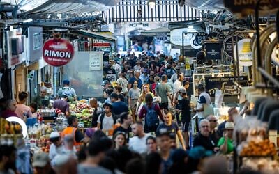 People shop at Jerusalem's Mahane Yehuda Market on September 25, 2022, on the eve of Rosh Hashanah. (Yonatan Sindel/Flash90)