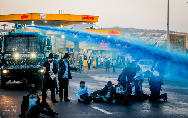 Ultra-Orthodox Jewish men clash with police as they protest against the arrest of a Haredi Jewish man who failed to comply with the mandatory military draft, in Jerusalem, September 29, 2022. (Olivier Fitoussi/ Flash90)
