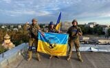 Ukrainian soldiers pose with a flag after retaking the town of Kupiansk near Kharkiv from Russian force, September 10, 2022. (Social media; used in accordance with Clause 27a of the Copyright Law)
