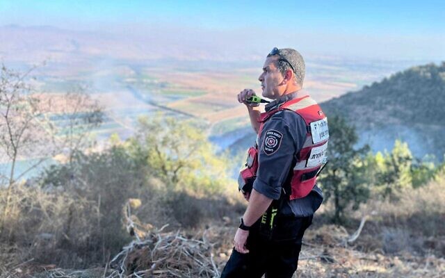 A firefighter looks on as fires spread in the Upper Galilee in Israel, September 28, 2022. (Fire and Rescue Authority)