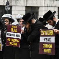 Members of US Haredi Jewish communities hold a protest before a Board of Regents meeting to vote on new requirements that private schools teach English, math science and history to high school students outside the New York State Education Department Building in Albany, New York, September 12, 2022. (Will Waldron/The Albany Times Union via AP)