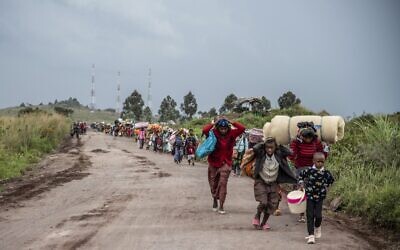 People walk on the road near Kibumba, north of Goma, Democratic Republic of Congo, as they flee fighting between Congolese forces and M23 rebels in North Kivu, May 24, 2022. Congolese authorities have accused Rwandan forces of supporting armed groups in mineral-rich eastern Congo, where dozens of such groups are active. Rwanda has described allegations of supporting rebels in Congo as baseless. (AP Photo/Moses Sawasawa)