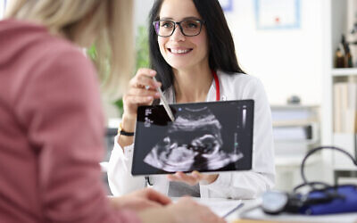 Illustrative image: a gynecologist showing a patient an ultrasound of her fetus. (megaflopp via iStock by Getty Images)
