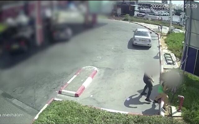 A suspect stabbing a woman with a broken glass bottle at a gas station in Rishon Lezion, central Israel, August 29, 2022. (Screen capture/Israel Police)