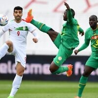Iran's forward Mehdi Taremi (L) and Senegal's midfielder Nampalys Mendy vie for the ball during the friendly football match between Senegal and Iran in Moedling, Austria on September 27, 2022. (JAKUB SUKUP / AFP)