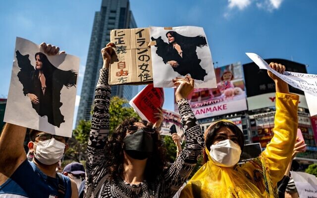 People chant slogans and hold the pictures of Mahsa Amini during the 'Freedom rally for Iran' event in Shibuya district of Tokyo on October 1, 2022 (Philip FONG / AFP)