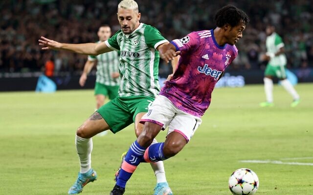 Maccabi Haifa's Israeli midfielder Omer Atzili (left) and Juventus' Colombian midfielder Juan Cuadrado fight for the ball during the UEFA Champions League group H football match between Israel's Maccabi Haifa and Italy's Juventus at the Sammy Ofer stadium in the city of Haifa on October 11, 2022. (RONALDO SCHEMIDT / AFP)