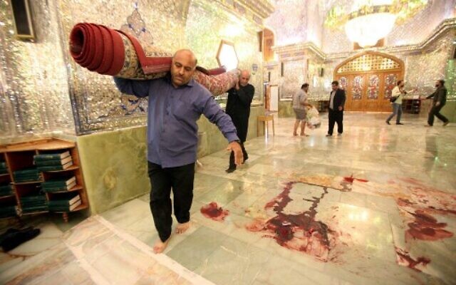 Workers clean up the scene following an armed attack at the Shah Cheragh mausoleum in the Iranian city of Shiraz, in which 15 people were killed, on October 26, 2022. (ISNA NEWS AGENCY/AFP)