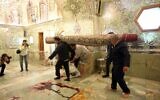 Workers clean up following an deadly armed attack at the Shah Cheragh mausoleum in the Iranian city of Shiraz on October 26, 2022. (Mohammadreza Dehdari/ISNA News Agency/AFP)