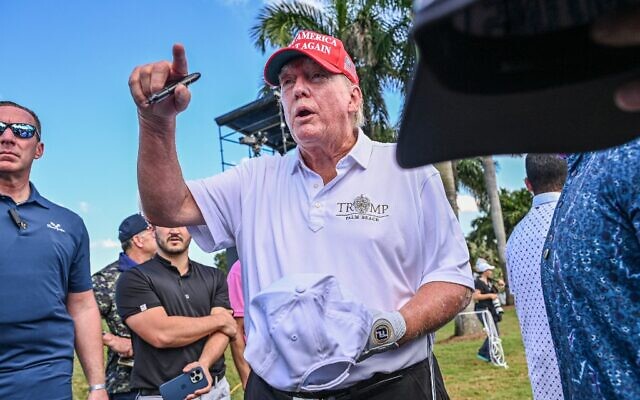 Former US President Donald Trump signs autographs as he walks off the seventh green a day ahead of the 2022 LIV Golf Invitational Miami at Trump National Doral Miami golf club in Miami, Florida, October 27, 2022. (Giorgio Viera/AFP)