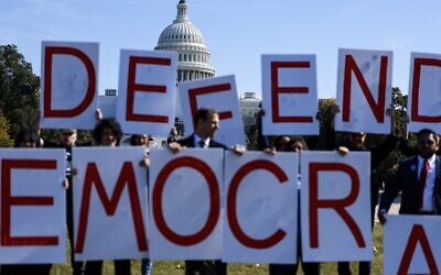 Activists hold up signs spelling out 'Defend Democracy' during a protest to call on accountability for the January 6th attack on the US Capitol Building on the National Mall  in Washington, DC, on October 20, 2022.  (Anna Moneymaker/Getty Images/AFP)