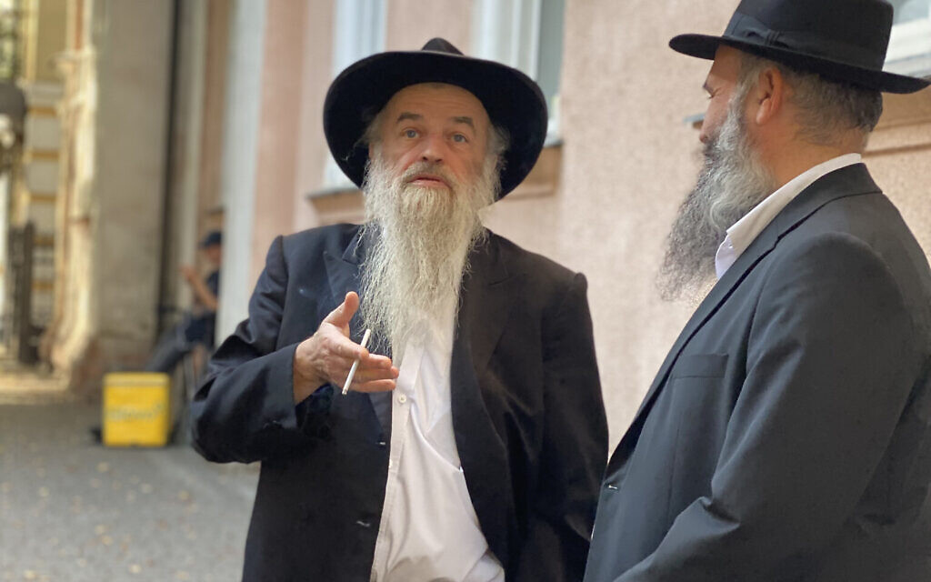 Rabbi Moyshe Kolesnik, the homegrown rabbi of Ivano-Frankivsk, smokes a cigarette outside his synagogue with a visiting rabbi from elsewhere in Ukraine. Since the Russian invasion, towns like Lviv and Ivano-Frankivsk have become crossroads for Ukrainian Jews entering and leaving the country. (Jacob Judah/ JTA)