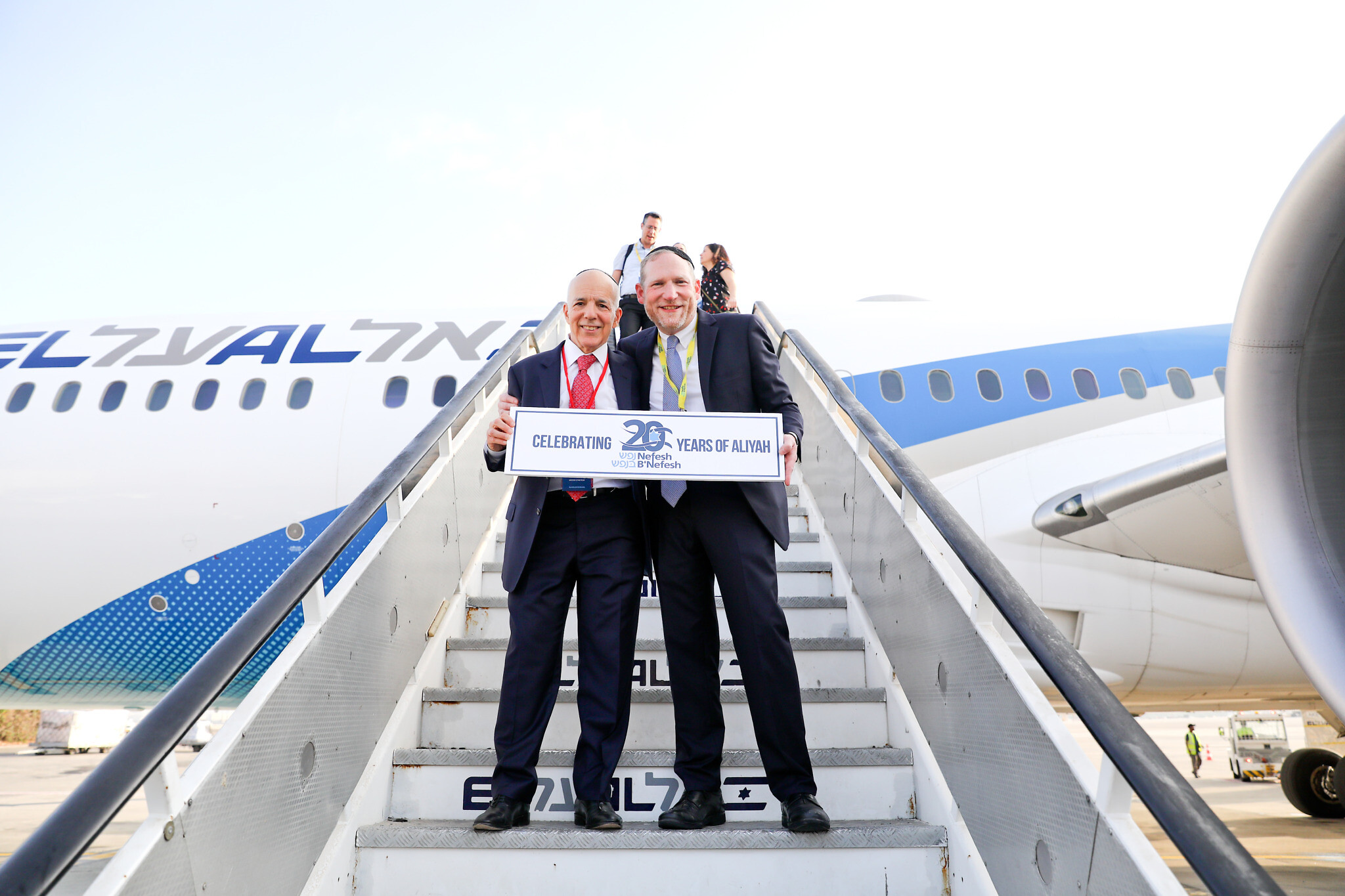 (2022Charter) – Co-Founders of NBN, Tony Gelbart and Rabbi Yehoshua Fass, de-plane 63rd charter Aliyah flight and celebrate 20 years of the organization (Photo credit: Yonit Schiller)