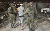 In this handout photo, IDF troops detain the Palestinian suspected of stabbing an Israeli man in the West Bank village of al-Funduq on October 25, 2022. (Israel Defense Forces)