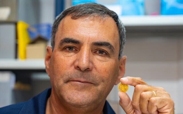 Dr. Yoav Lerer, excavation director, with one of the gold coins found in a hoard at the Banias archeological site. (Yaniv Berman/Antiquities Authority)