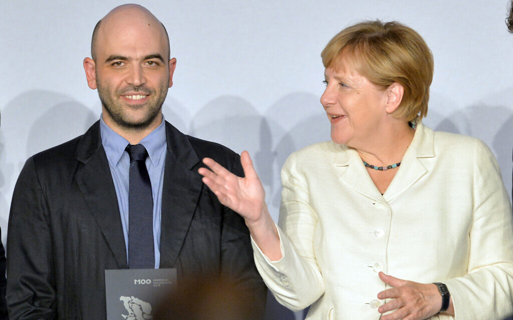 Italian journalist and prize winner Roberto Saviano, left, poses with German Chancellor Angela Merkel at the M100 international media conference in Potsdam, Germany, September 15, 2016. (Ralf Hirschberger/Pool Photo via AP)
