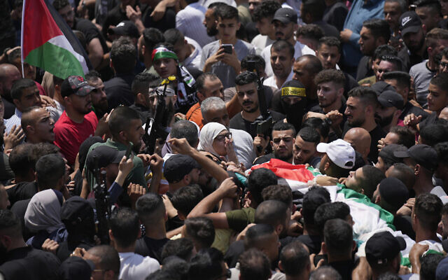 A Palestinian woman blows a kiss to the body of her son, Ibrahim Nabulsi, during his funeral in the West Bank town of Nablus, Tuesday, Aug. 9, 2022.  (AP Photo/Majdi Mohammed)