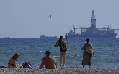 Illustrative: People on the beach take photos of the 'Tungsten Explored' drilling ship, in the southern coastal city of Larnaca, Cyprus, November 3, 2021. (AP Photo/Petros Karadjias, File)