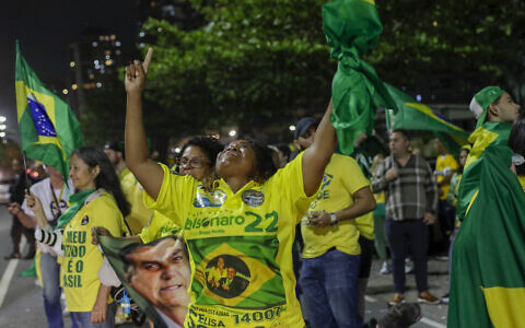 Supporters of Brazilian President Jair Bolsonaro, who is running for another term, celebrate partial results after general election polls closed outside his family home in Rio de Janeiro, Brazil, Sunday, Oct. 2, 2022. (AP/Bruna Prado)