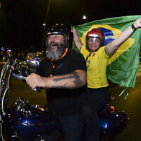 Supporters of Brazilian President Jair Bolsonaro ride a motorcycle after the general election polls closed in Brasilia, Brazil, Sunday, Oct. 2, 2022. (AP/Ton Molina)