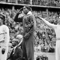 America's Jesse Owens, center, salutes during the presentation of his gold medal for the long jump, alongside silver medalist Luz Long, right, of Germany, and bronze medalist Naoto Tajima, of Japan, during the 1936 Summer Olympics in Berlin, August 11, 1936  (AP Photo/File)