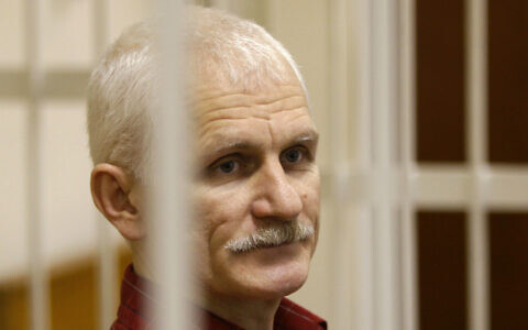 FILE - Ales Bialiatski, the head of Belarusian Vyasna rights group, stands in a defendants' cage during a court session in Minsk, Belarus, on November 2, 2011. (AP Photo/Sergei Grits, File)