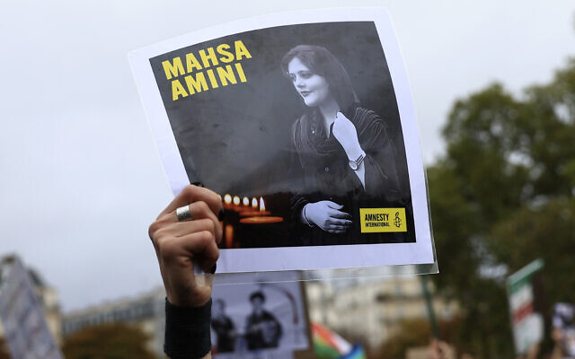 FILE - A protester shows a portrait of Mahsa Amini during a demonstration to support Iranian protesters standing up to their leadership over the death of a young woman in police custody, October 2, 2022 in Paris. (AP Photo/Aurelien Morissard)
