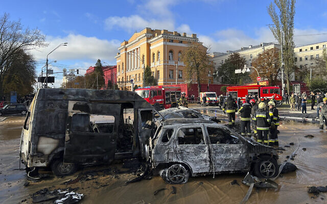 Rescue workers survey the scene of a Russian attack on Kyiv, Ukraine on October 10, 2022. (AP Photo/Adam Schreck)